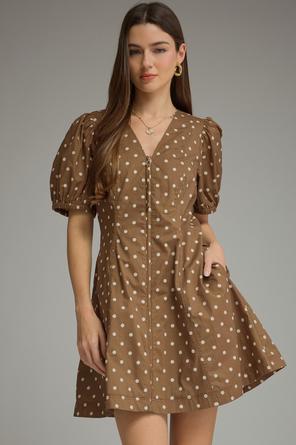 A playful cotton polka dot mini dress featuring feminine puff sleeves, a flattering V-neckline, and convenient side pockets.

