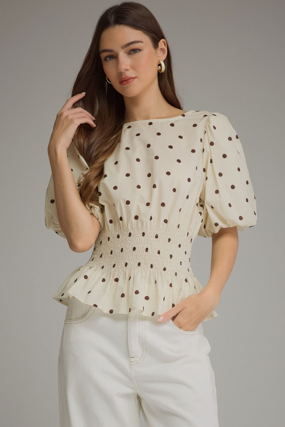 The Claudette Polka Dot Peplum Top brings playful vintage-inspired charm to your wardrobe with puff sleeves, a smocked waist, and a feminine ruffle hem.
