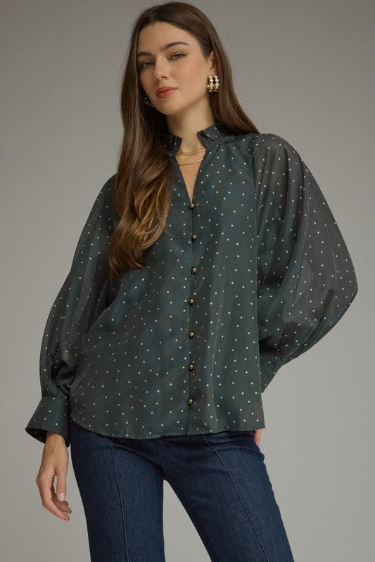 A lightweight polka dot blouse featuring a feminine ruffled neckline, button-front detail, and elegant long sleeves for effortless boutique style.