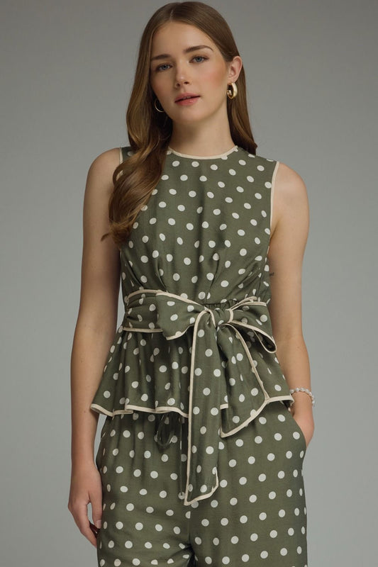 A timeless polka dot sleeveless top featuring a flattering tie waist and contrast trim for an effortlessly polished look.
