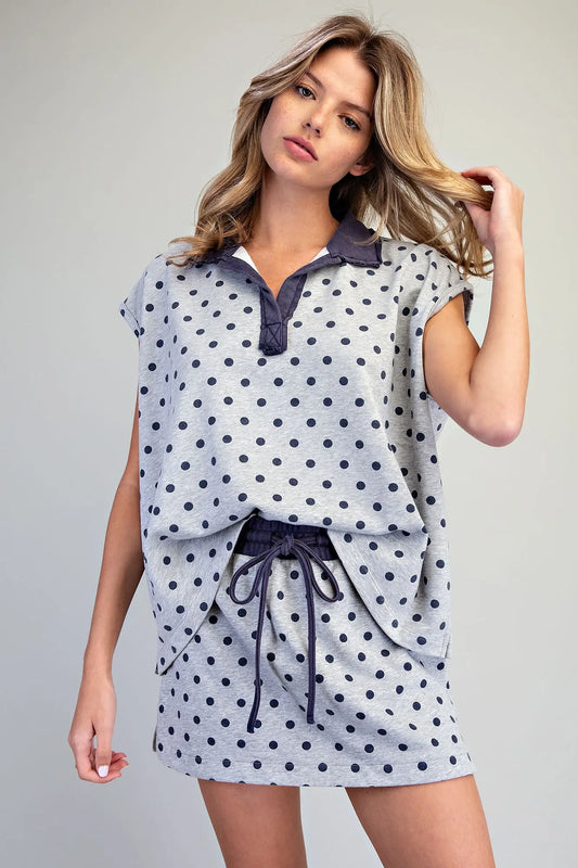 A relaxed mineral washed polo top featuring playful polka dots, cap sleeves, and a raw edge collar for effortless casual style.
