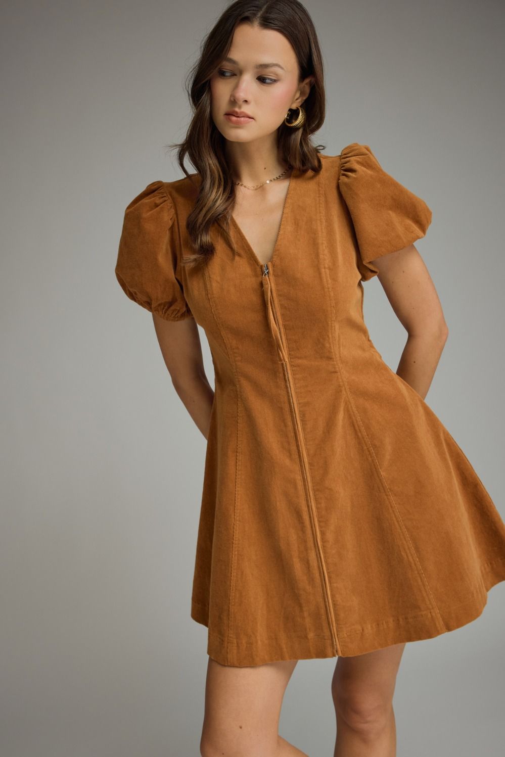 A feminine and effortlessly flattering mini dress featuring a V-neckline, romantic puff sleeves, convenient side pockets, and an easy front zipper closure.