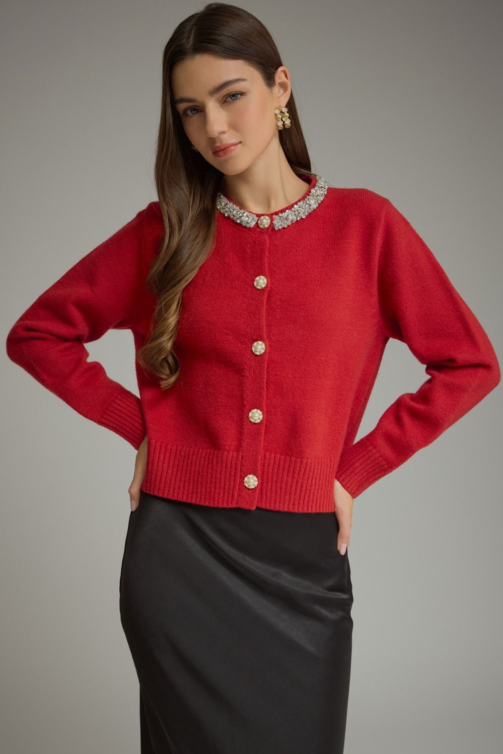 A polished knit cardigan featuring elegant rhinestone and pearl trim, pearl buttons, and classic ribbed details for a sophisticated feminine finish.