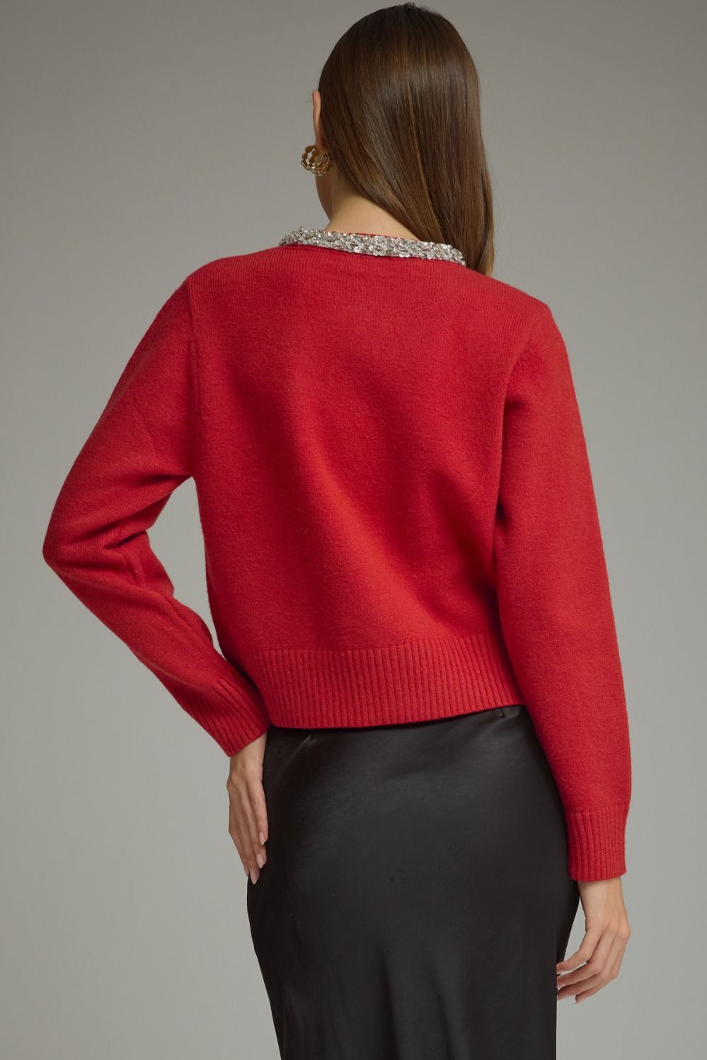 A polished knit cardigan featuring elegant rhinestone and pearl trim, pearl buttons, and classic ribbed details for a sophisticated feminine finish.