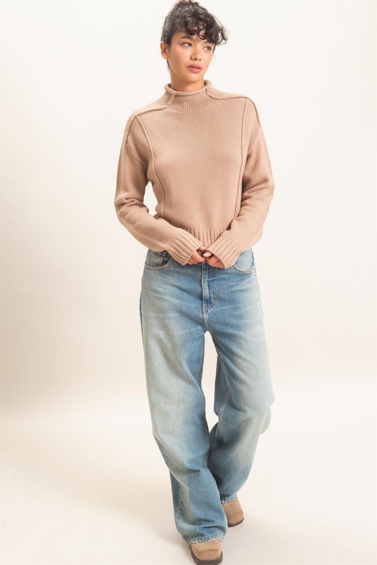 A cozy mid-weight roll neck sweater featuring distinctive reverse seam details, ribbed trim, and a relaxed silhouette for effortless everyday style.