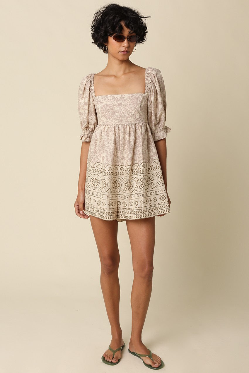 A breezy printed babydoll romper featuring a vintage-inspired print, square neckline, puff sleeves, and a flattering smocked back for effortless all-day style.

