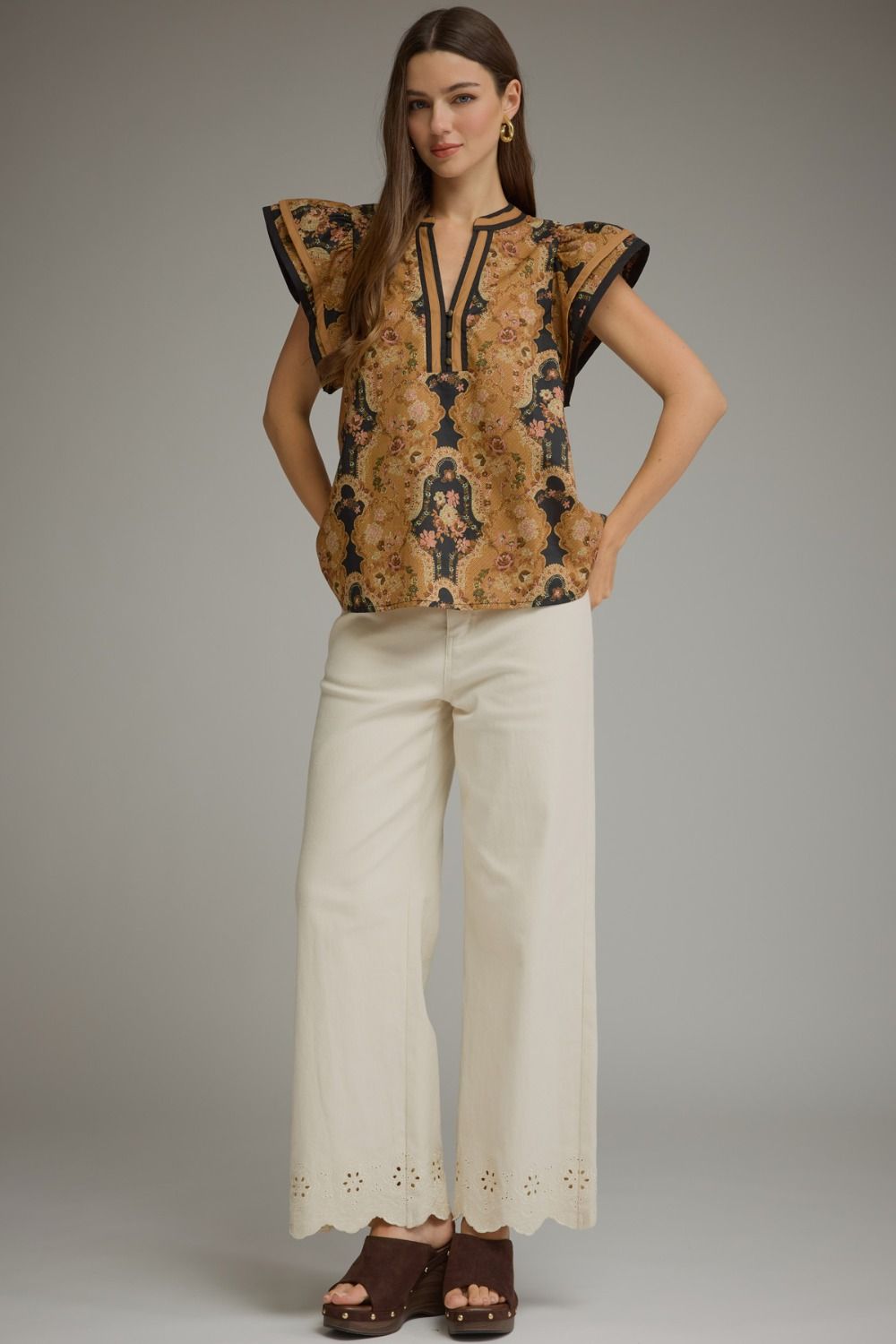 A feminine floral cotton top featuring romantic ruffle cap sleeves, contrast trim, and a flattering split neckline for effortless everyday elegance.