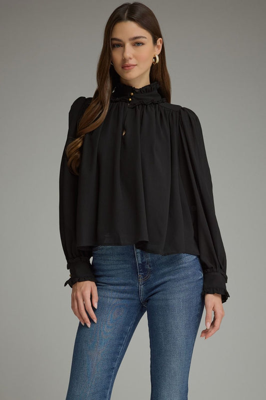 A romantic long sleeve blouse featuring a ruffled high neckline, gathered details, voluminous sleeves, and delicate ruffle-trimmed cuffs.

