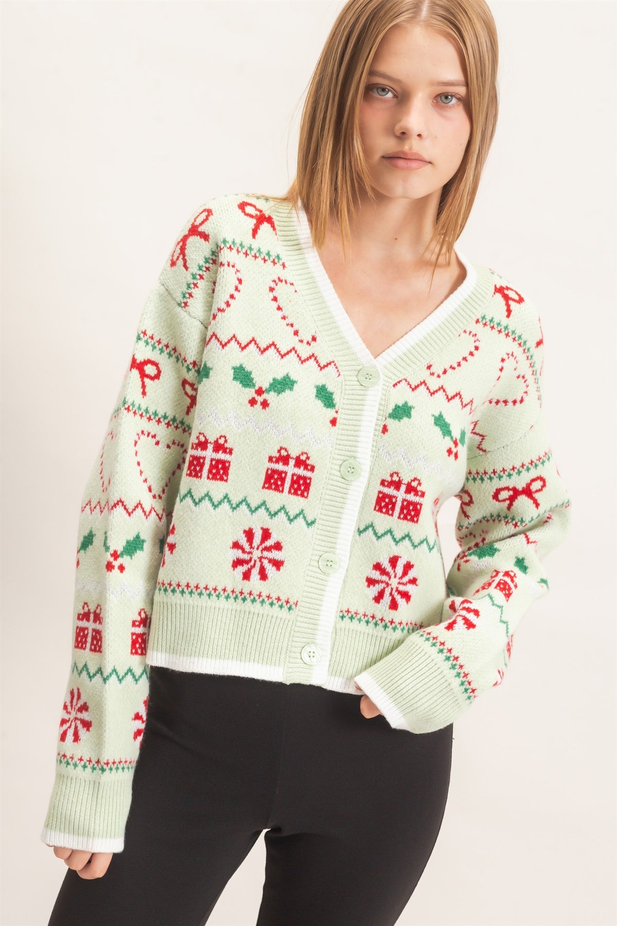A festive cropped cardigan featuring a charming holiday jacquard pattern, classic button front, and polished contrast edging.

