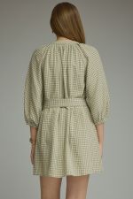 A timeless gingham mini dress featuring ¾ sleeves, a self-tie waist belt, and a button-front design for effortlessly polished style.
