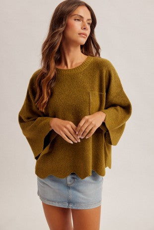 A cozy statement sweater featuring scalloped edges, dramatically wide sleeves, and cute pocket details for effortless everyday style.