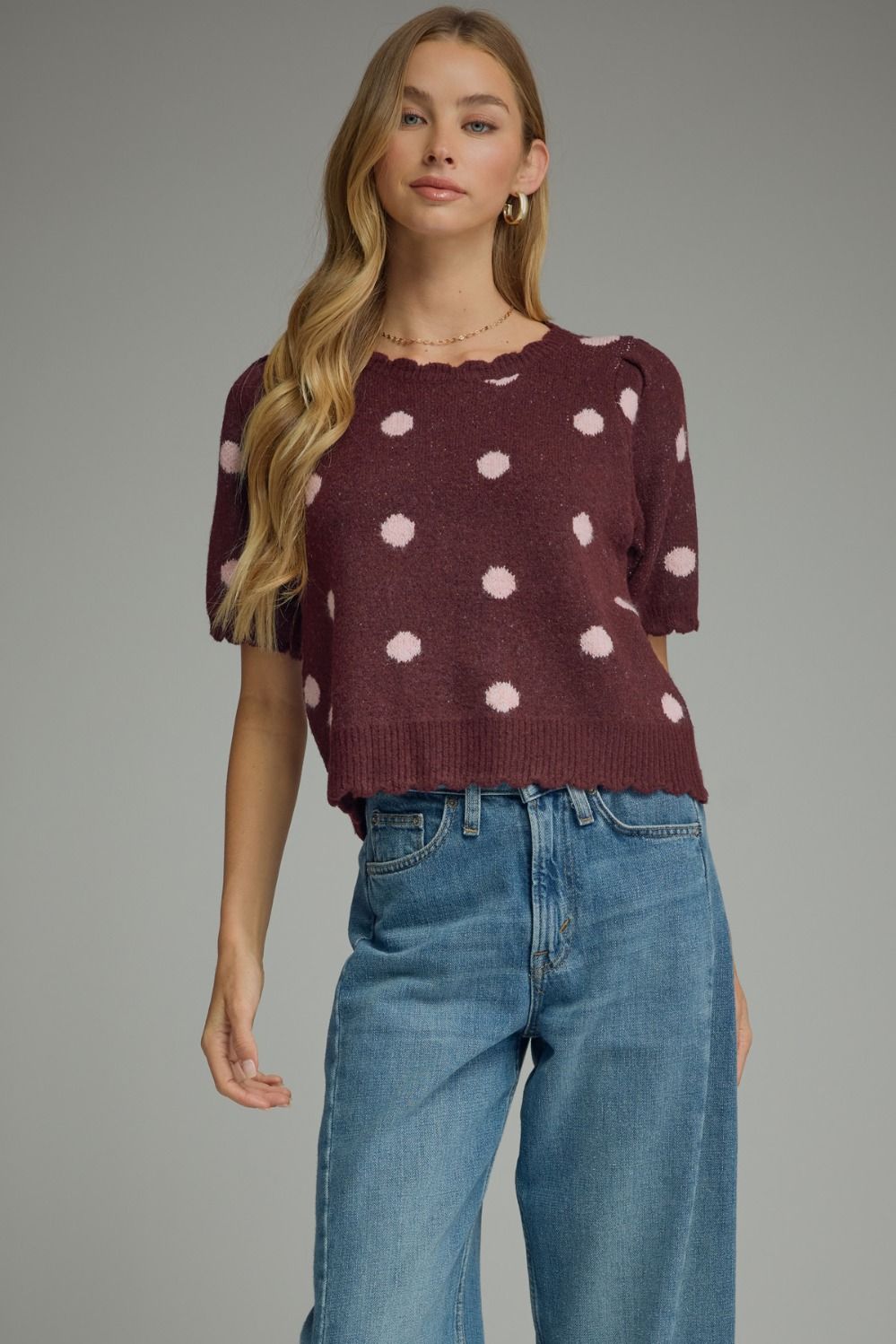 this lightweight polka dot knit top features feminine puff sleeves and delicate scalloped trim for timeless boutique style.