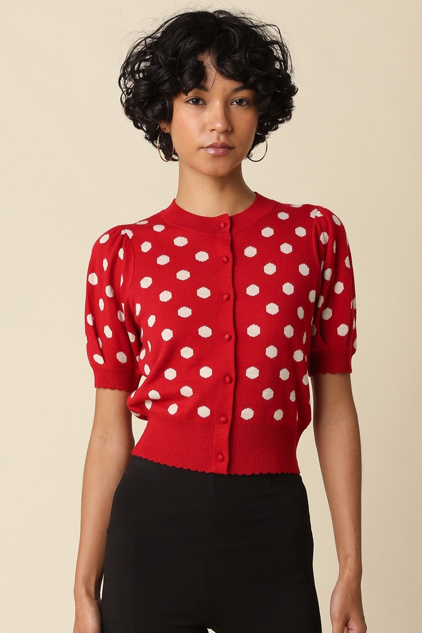 A feminine cropped polka dot cardigan featuring short puff sleeves, a scalloped hem, and a flattering fitted silhouette in a soft stretch wool blend.