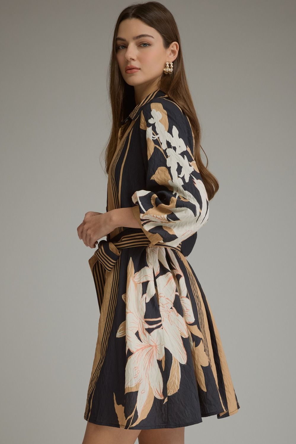 A feminine printed mini dress featuring dramatic balloon sleeves, a classic shirt collar, button-front closure, and a flattering self-tie waist.
