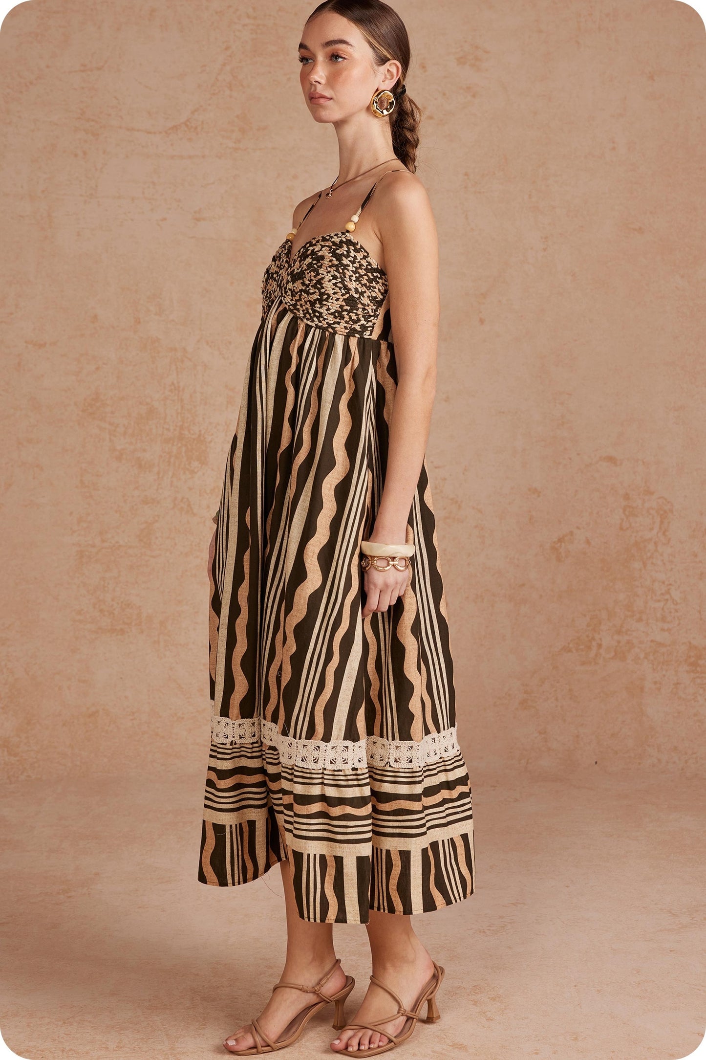 Effortlessly elegant and perfect for sunny days, this printed linen midi dress features delicate braided details and spaghetti straps for a timeless, feminine look.

