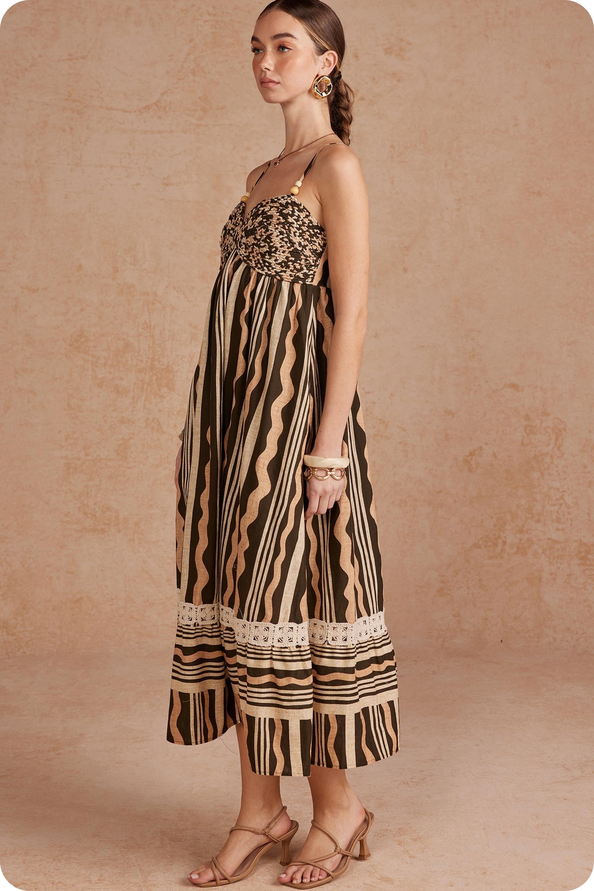 Effortlessly elegant and perfect for sunny days, this printed linen midi dress features delicate braided details and spaghetti straps for a timeless, feminine look.

