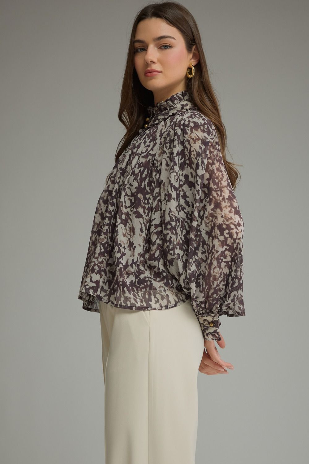 A romantic printed blouse featuring voluminous puff sleeves, a feminine ruffle neckline, and delicate gathered details for an effortlessly polished look.