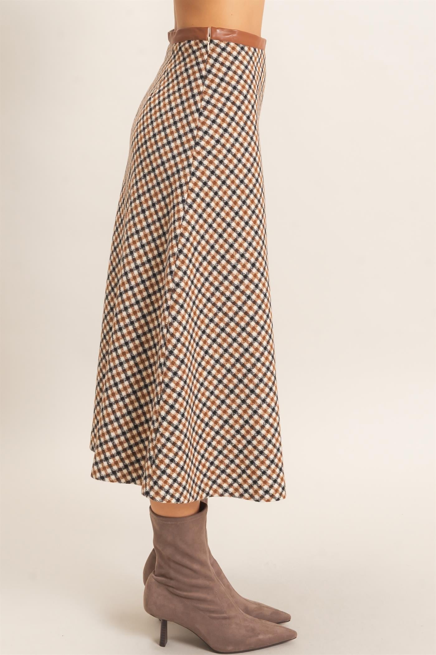 A sophisticated checkered A-line midi skirt featuring a sleek faux leather waistband and flattering flare for effortlessly polished style.
