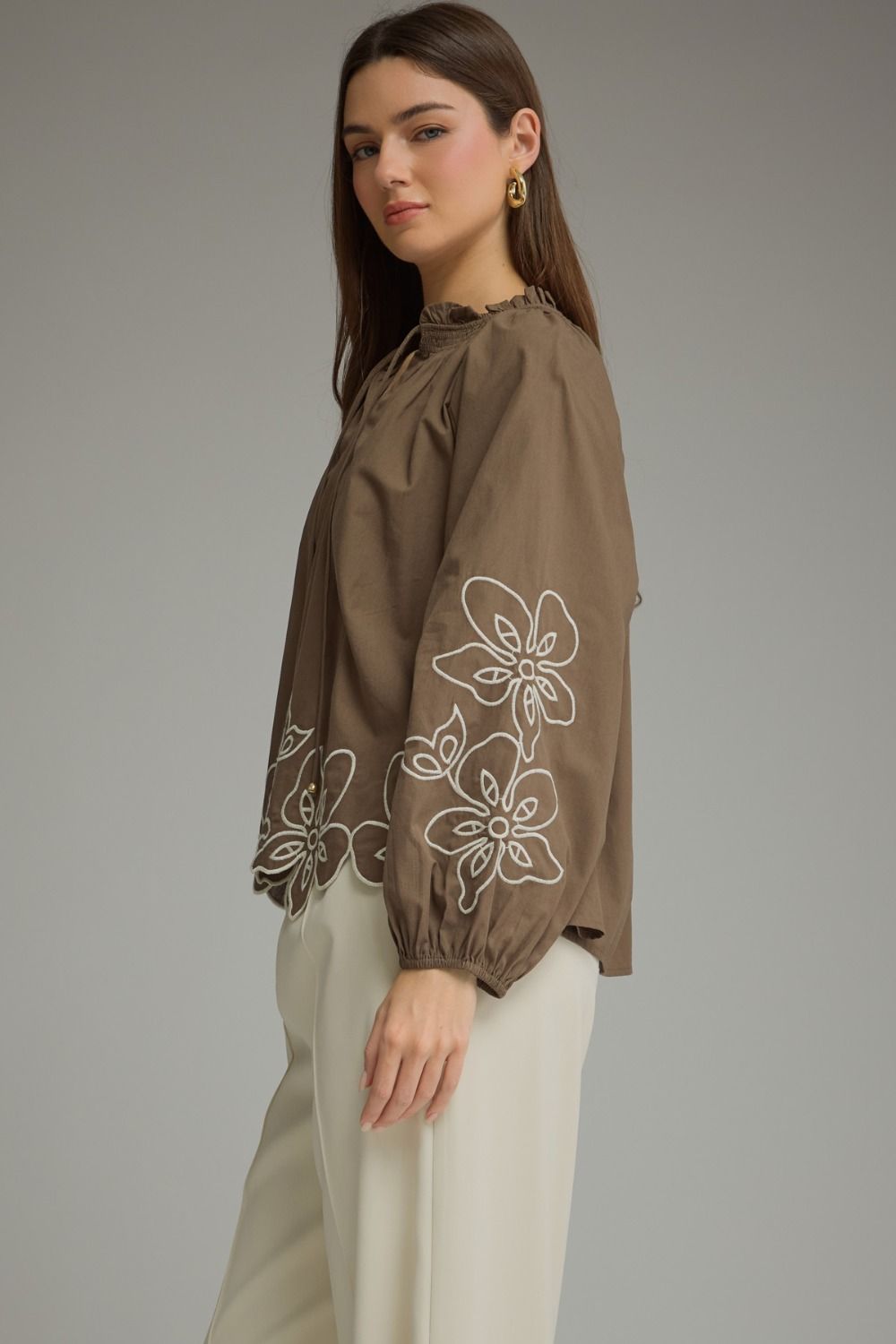 A charming lightweight woven top featuring a romantic ruffle neckline, self-tie front, and delicate embroidery for effortlessly feminine style.

