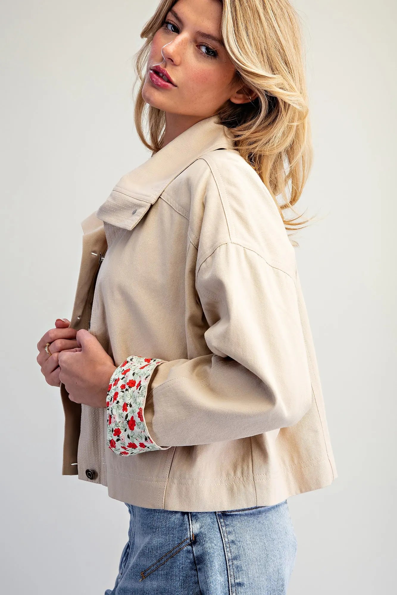 The Marjorie Floral Lined Cropped Jacket pairs a relaxed beige silhouette with a vibrant floral lining for a sophisticated statement layer with a playful twist.
