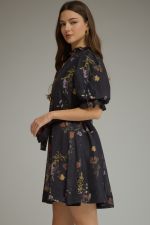 A romantic floral mini dress featuring puff sleeves, a self-tie waist belt, and a ruffled V-neckline for effortlessly feminine style.
