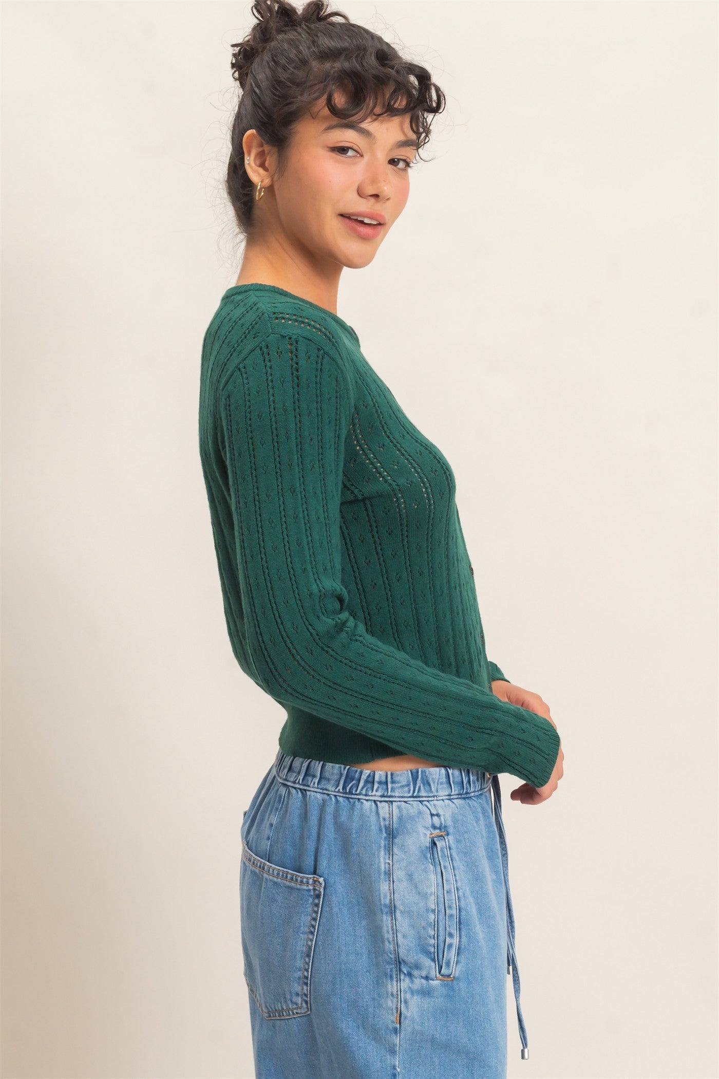 A timeless pointelle knit cardigan featuring a classic button-front design, ribbed crew neckline, and a tailored silhouette for effortless everyday elegance.