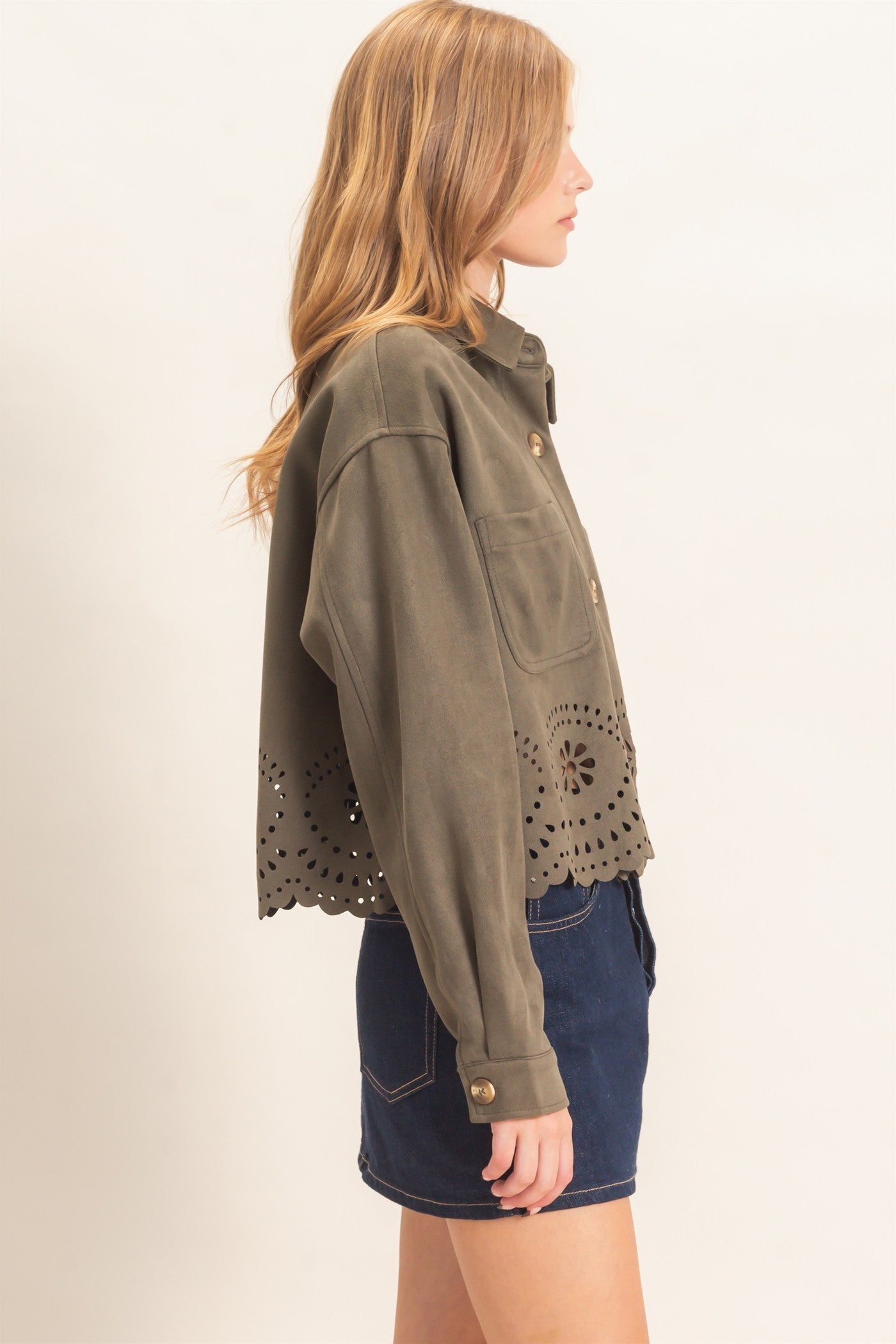 A beautifully structured suede jacket with button-front styling, chest pockets, relaxed drop shoulders, and an intricate laser-cut floral hem.