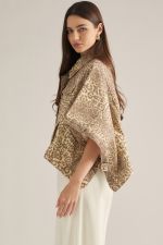 A statement-making animal print jacket featuring dramatic poncho sleeves, a button front, and convenient pockets in a soft cotton-blend fabric.

