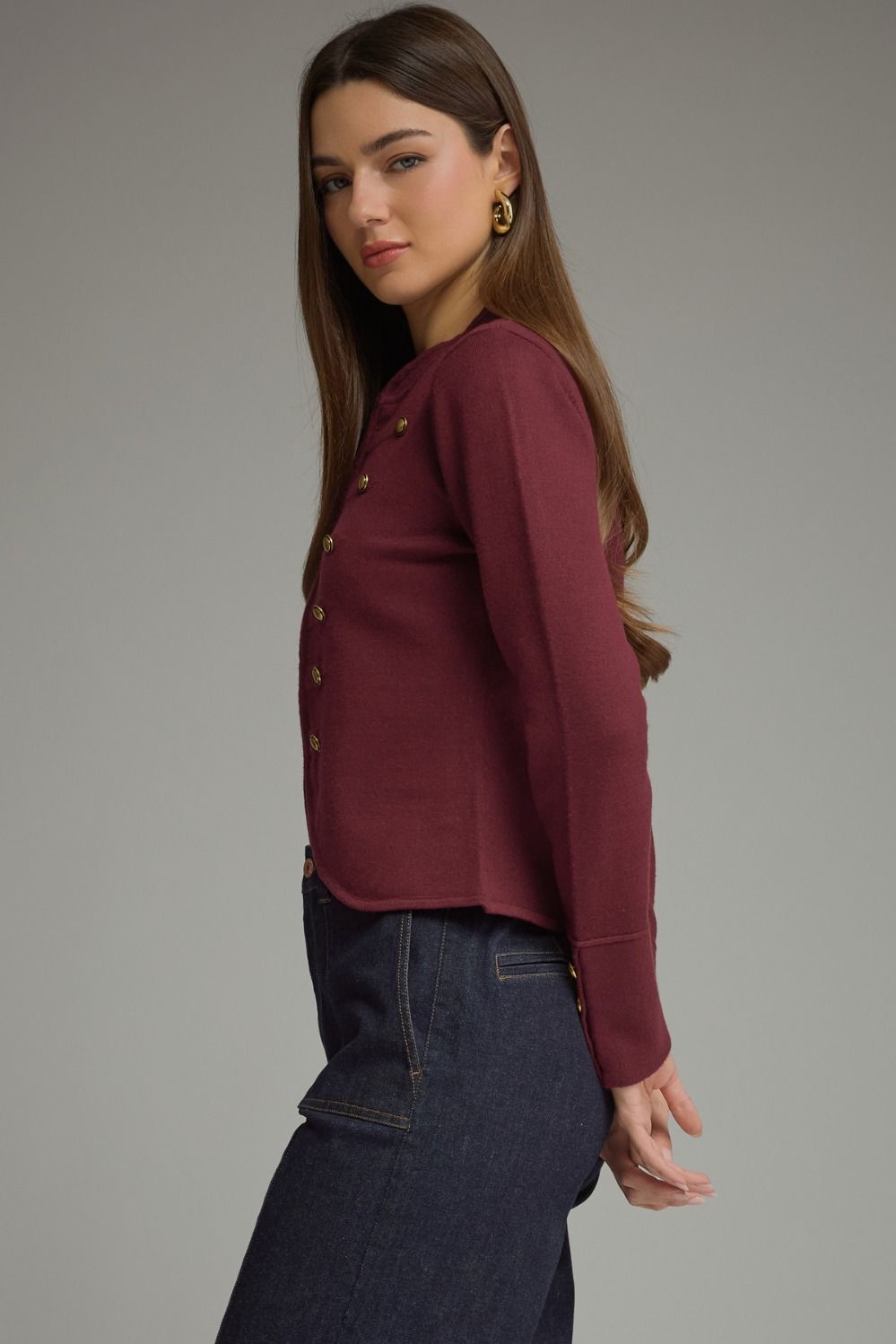 A polished knit jacket featuring a classic round neckline, zip-front closure, decorative buttons, and refined button details at the cuffs.


