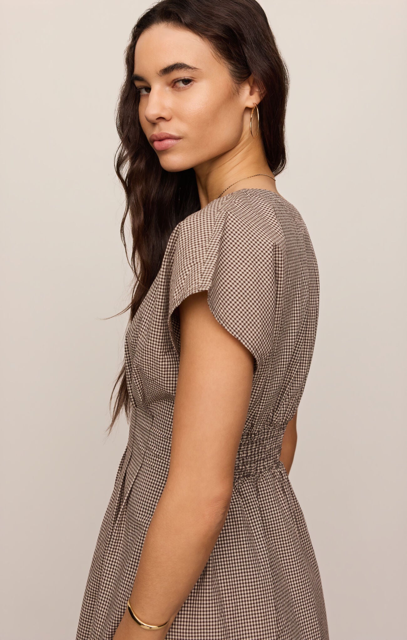 A cotton poplin shirt dress featuring a classic gingham print, flattering V-neckline, and button-front design for effortless everyday sophistication.
