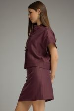 A polished two-piece set featuring a chic cropped top with wide cuffed sleeves paired with a sleek mini skirt for an effortlessly coordinated look.