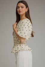 The Claudette Polka Dot Peplum Top brings playful vintage-inspired charm to your wardrobe with puff sleeves, a smocked waist, and a feminine ruffle hem.
