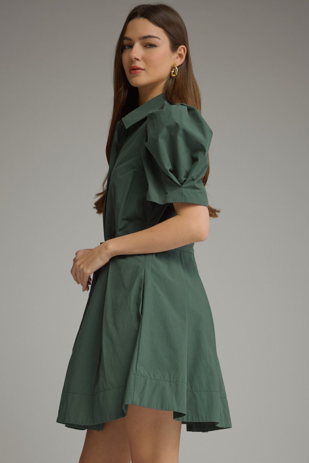 A feminine mini dress featuring playful puff sleeves, a classic shirt collar, waist tie detail, and a beautifully pleated skirt.


