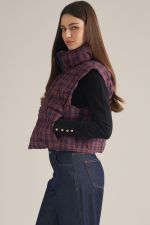 A cozy-chic plaid vest featuring a high neck, padded quilted construction, and a convenient front zipper for effortless layering through the cooler seasons.
