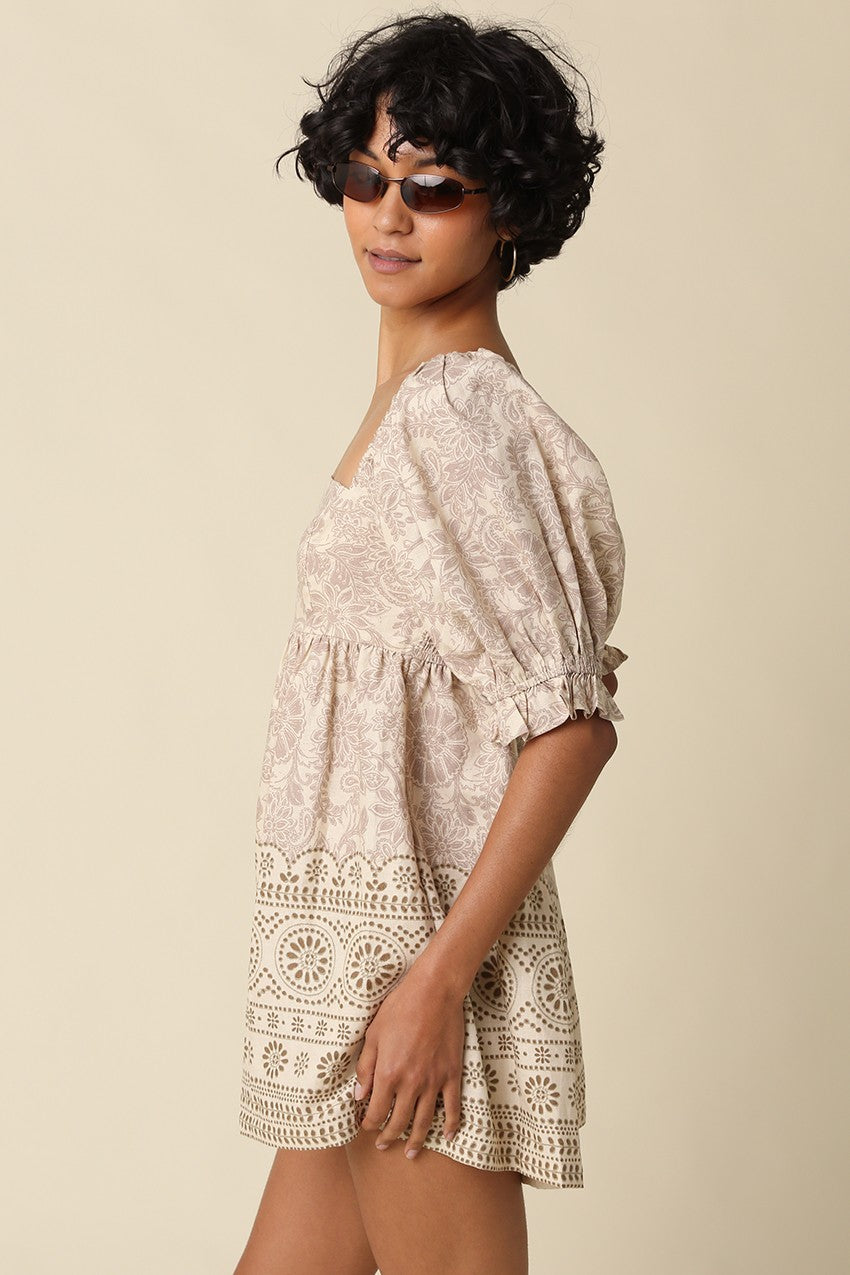 A breezy printed babydoll romper featuring a vintage-inspired print, square neckline, puff sleeves, and a flattering smocked back for effortless all-day style.
