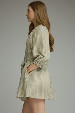 A timeless gingham mini dress featuring ¾ sleeves, a self-tie waist belt, and a button-front design for effortlessly polished style.
