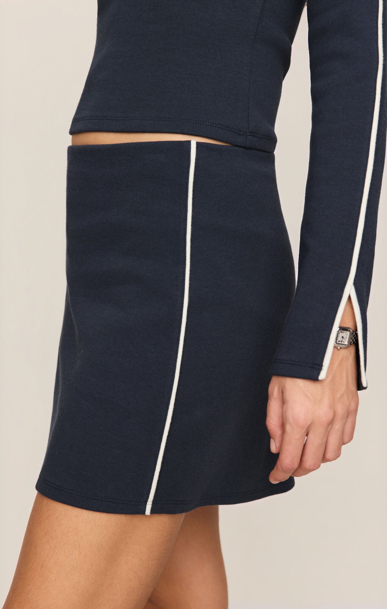 A chic high-rise knit skort featuring a flattering mini silhouette with built-in bike shorts for effortless comfort and confident style.