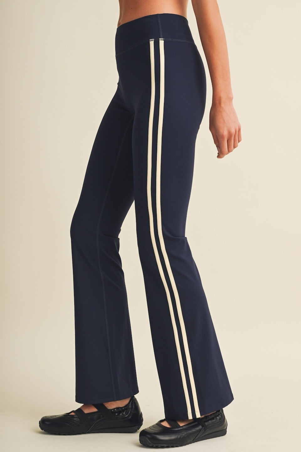 A sporty, figure-flattering take on the classic flare legging, featuring a low-rise waist, contrast side stripes, and a fitted silhouette that flows into a sleek flared hem.
