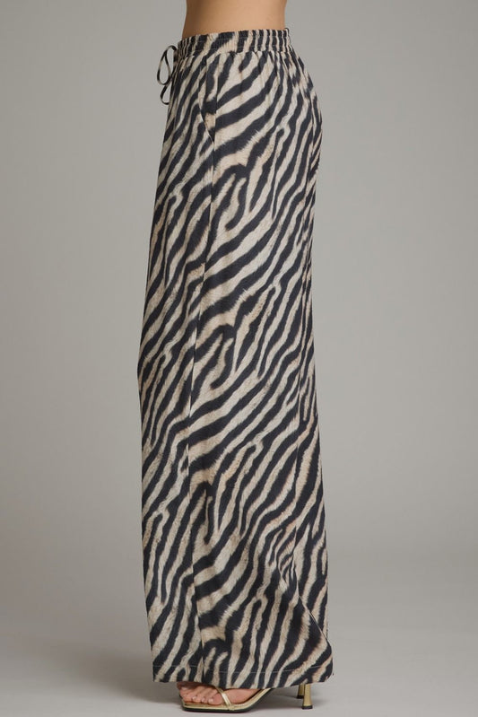 Make a bold statement in these lightweight zebra print wide leg pants featuring a comfortable elastic waistband and adjustable drawstring detail.