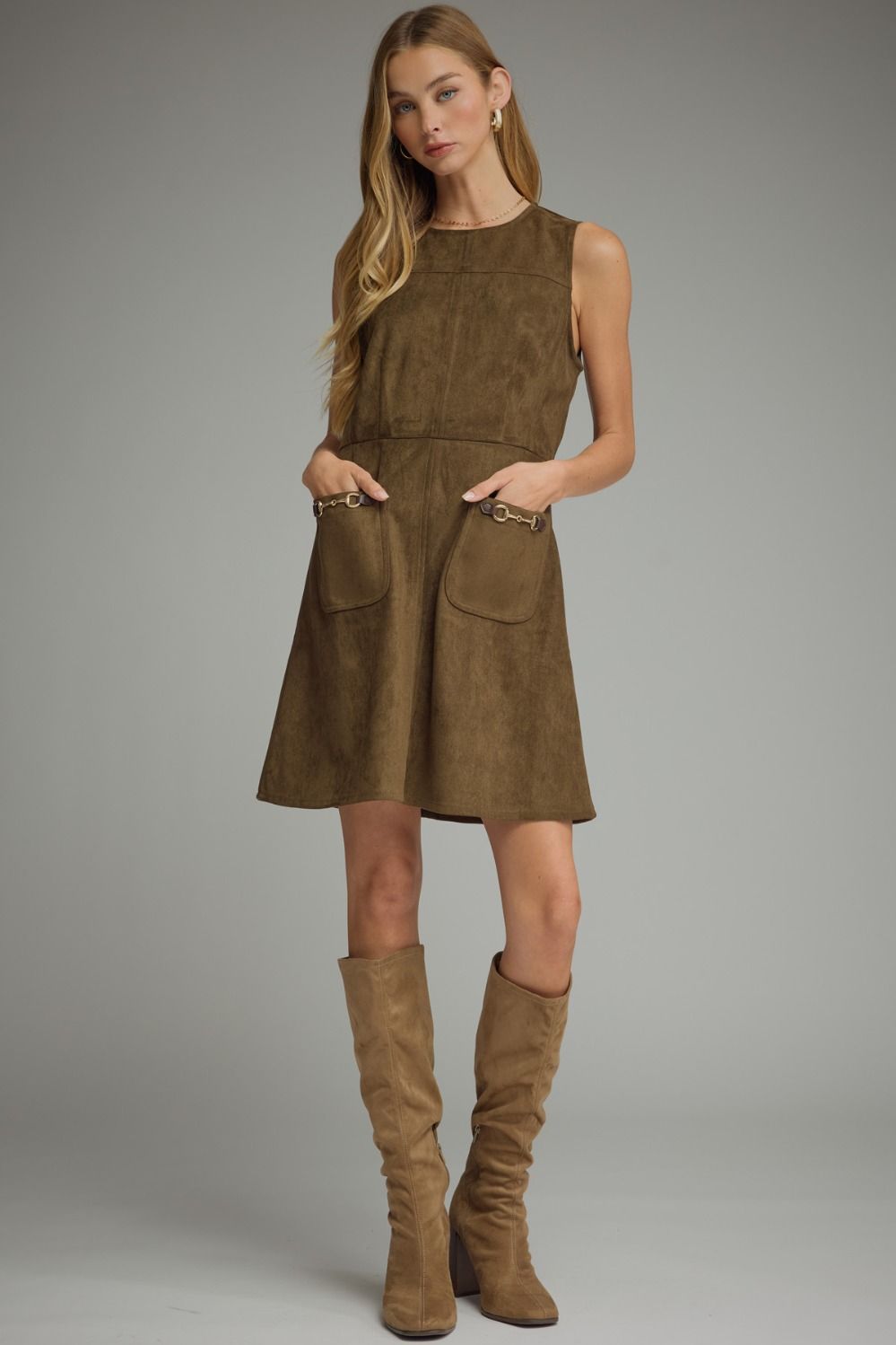 A sleek sleeveless mini dress featuring statement front pockets with metallic chain trim and a clean back-zip closure.