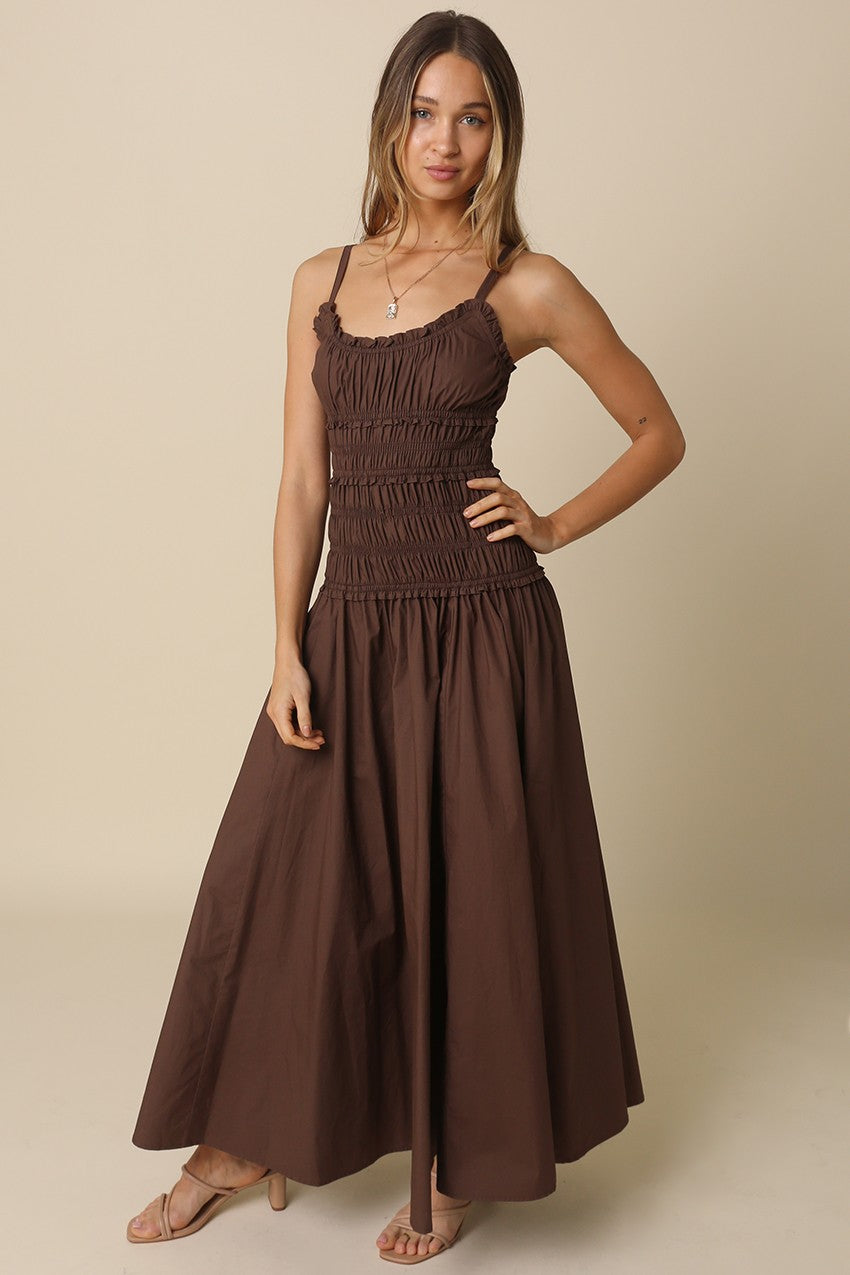 A breezy cotton maxi dress featuring a flattering smocked bodice, front cutout detail, adjustable straps, and a flowy silhouette made for sunny days.