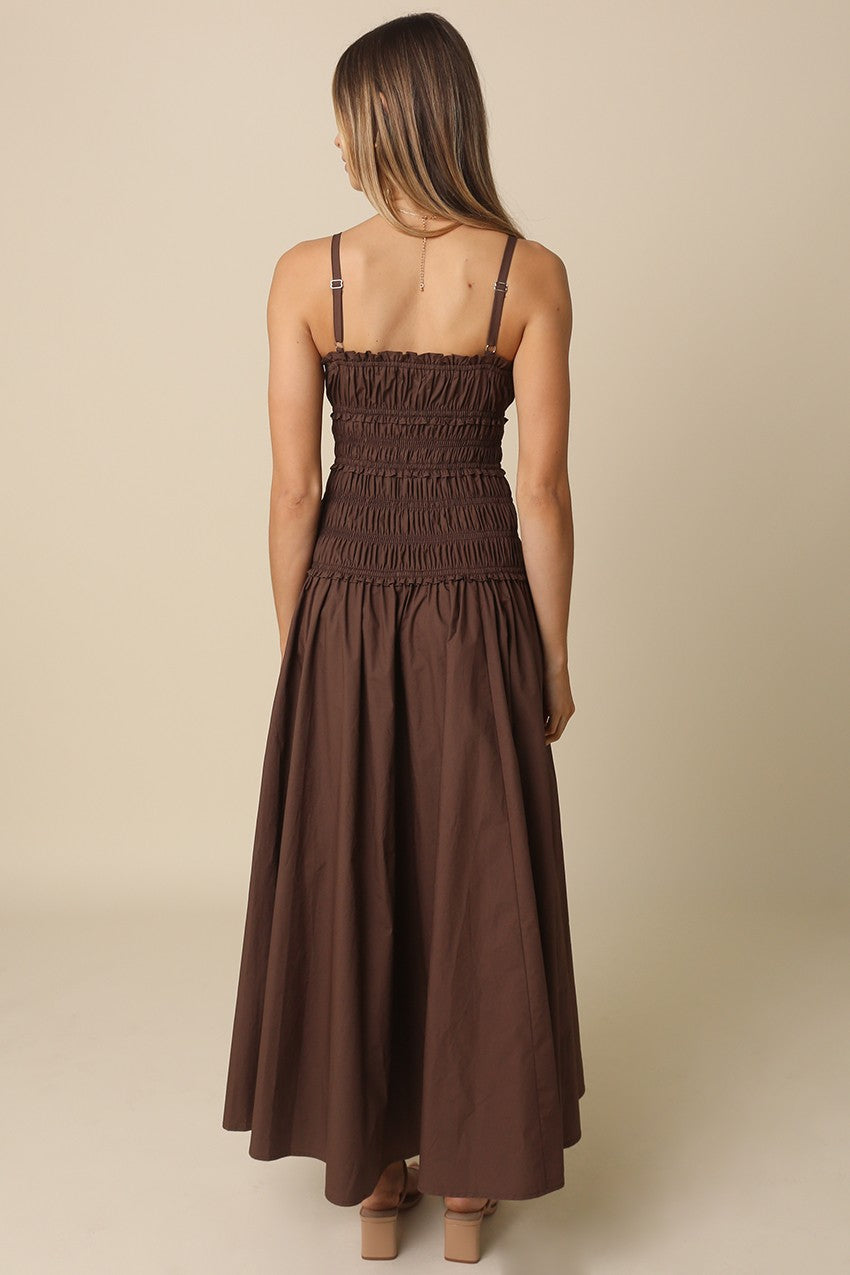 A breezy cotton maxi dress featuring a flattering smocked bodice, front cutout detail, adjustable straps, and a flowy silhouette made for sunny days.