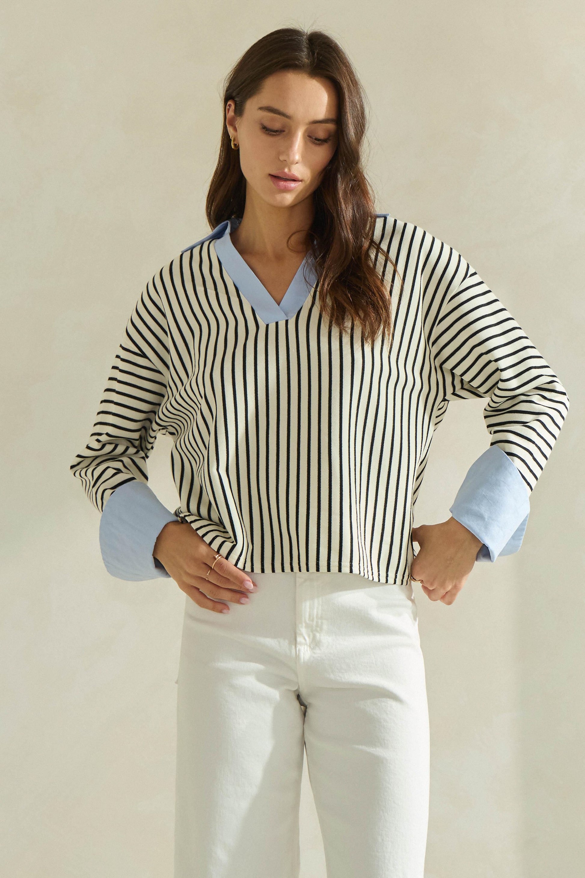 A timeless striped knit top featuring a flattering V-neckline, contrast neckline and cuffs, and an effortlessly polished silhouette.