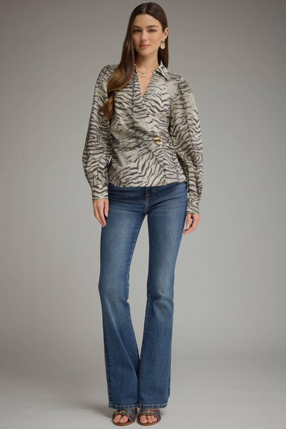 Make a bold style statement with this animal print crossover top featuring voluminous puff sleeves, a flattering buckle waist, and a feminine V-neckline.

