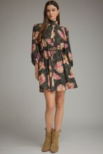 A feminine printed mini dress featuring ¾ balloon sleeves, a stand collar, adjustable drawstring waist, and convenient side pockets.

