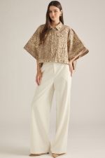 A statement-making animal print jacket featuring dramatic poncho sleeves, a button front, and convenient pockets in a soft cotton-blend fabric.

