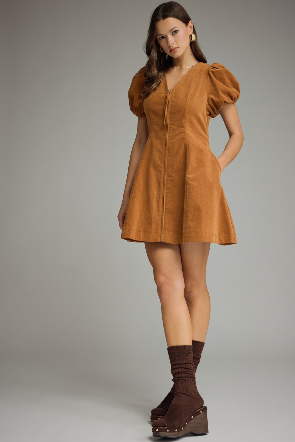 A feminine and effortlessly flattering mini dress featuring a V-neckline, romantic puff sleeves, convenient side pockets, and an easy front zipper closure.