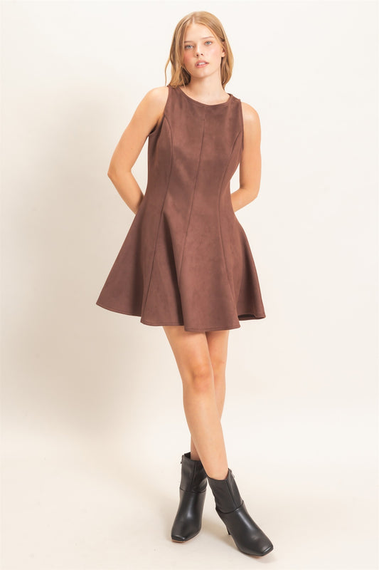 A sophisticated sleeveless suede mini dress with a classic round neckline and flattering flared silhouette that effortlessly transitions from day to night.
