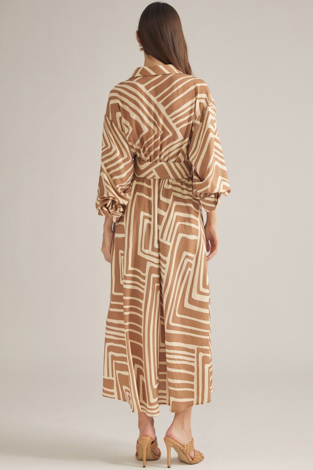 A sophisticated geometric print midi dress featuring balloon sleeves, a removable belt, and a flattering button-front silhouette.

