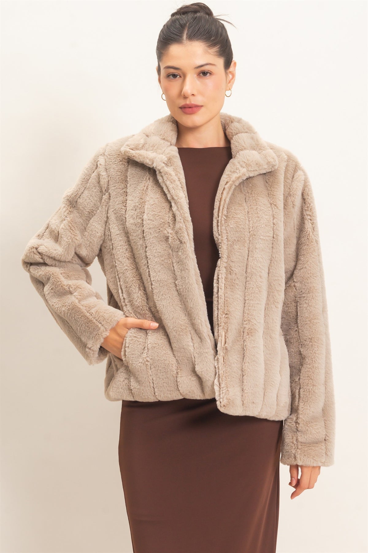 A luxurious faux fur jacket featuring a clean silhouette, cozy warmth, functional pockets, and an easy hook-and-eye front closure.

